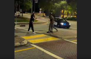 Police Sits In His Car While Two Men Throw Hands Right In Front Of Him
